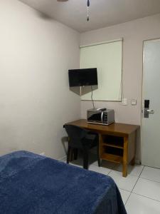 a bedroom with a desk with a computer and a television at Habitacion C10 privada centro monterrey in Monterrey