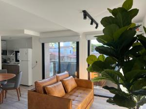 a living room with a brown couch and a table at Nogales Apartamentos in Mar del Plata