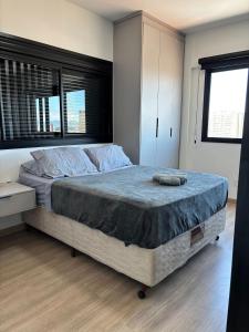 a bedroom with a large bed and a window at Apt completo: ar cond piscina e academia no Centro in Taubaté
