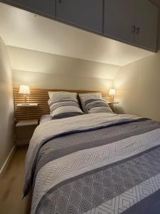 ein Schlafzimmer mit einem großen Bett mit zwei Kissen in der Unterkunft La Naturelle 123 - Duplex Vue Mer Wimereux in Wimereux