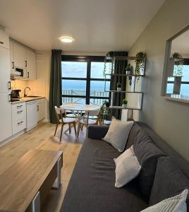 ein Wohnzimmer mit Sofa und Tisch in der Unterkunft La Naturelle 123 - Duplex Vue Mer Wimereux in Wimereux