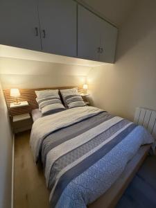 ein Schlafzimmer mit einem großen Bett mit zwei Kissen in der Unterkunft La Naturelle 123 - Duplex Vue Mer Wimereux in Wimereux + 21 Fotos