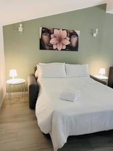 a bedroom with a large white bed with two pictures on the wall at PsApart in Augusta