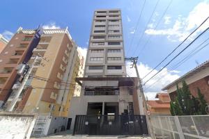 a tall building in front of two tall buildings at Apt completo: ar cond piscina e academia no Centro in Taubaté