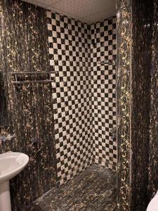a bathroom with a black and white checkered shower at Shouel Inn Furnished Apartments in Makkah