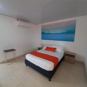 a bedroom with a bed and a painting on the wall at Hotel Mare Mare Inn in San Andrés