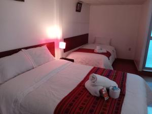 een hotelkamer met 2 bedden en handdoeken op het bed bij Casa Hospedaje Sunya in Cuzco +24 foto's