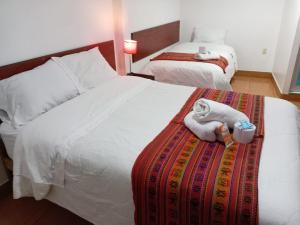 een hotelkamer met 2 bedden en handdoeken erop bij Casa Hospedaje Sunya in Cuzco