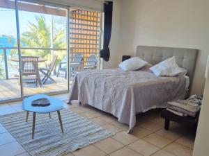 a bedroom with a bed and a table and a balcony at Studio with a view of a heavenly lagoon in Bora Bora