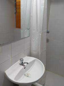 een badkamer met een witte wastafel en een douche bij Casa Hospedaje Sunya in Cuzco