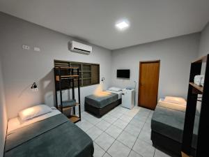 a bedroom with two bunk beds and a tv at Hotel Pousada Narandiba in Narandiba