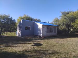 a small white house in a field with trees at Arcoiris de Cortaderas in Cortaderas +2 photos