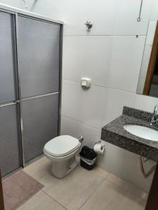 a bathroom with a toilet and a shower and a sink at Suíte com ar, frigobar atende até 3 pessoas não a estacionamento in Sinop