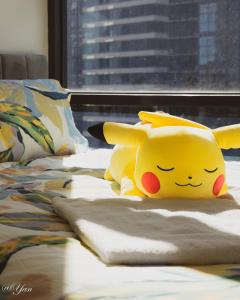 a hello kitty stuffed animal sitting on a bed at Trainer's Cozy Home - Town of Beginnings マサラタウンのトレーナーのおうち in Melbourne