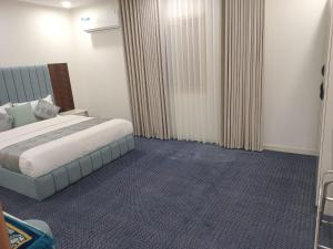 a hotel room with a bed and curtains at فيلمست ريزدنس ابها للشقق الفندقية Velmist Residence Abha in Abha