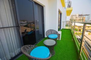 Luxury one bedroom apartment lekki phase 1 في ليكى: شرفة مع ثلاثة كراسي وطاولات على شرفة