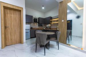 Luxury one bedroom apartment lekki phase 1 في ليكى: مطبخ مع طاولة وكراسي في الغرفة