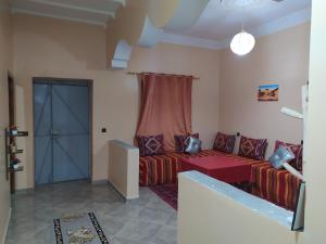 a living room with a couch and a blue door at Sahara Dream Apartment in Merzouga