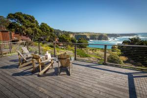 a wooden deck with chairs and a view of the ocean at Heritage House Resort & Spa in Little River