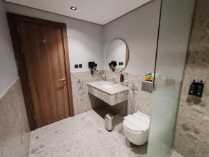 a bathroom with a sink and a toilet and a mirror at HDN Hotel فندق هدن in Mecca +19 photos
