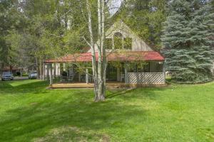 a house with a red roof on a green yard at Circle 4 Condo 14 in Sunriver