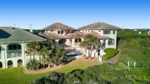 Chateau of the Isle by Emerald Isle Realty في Salter Path: اطلالة جوية على بيت كبير فيه نخيل