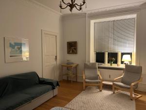 a bedroom with two chairs and a bed and a window at Topcity in Copenhagen