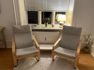 two chairs and a table in a room with a window at Topcity in Copenhagen