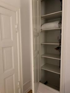 a closet with white shelves and a door at Topcity in Copenhagen
