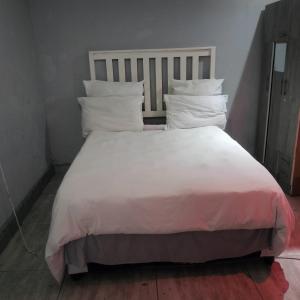 a large bed with white sheets and pillows at N2 Village BnB in Hadi