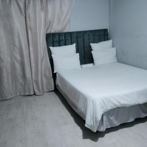 two beds in a room with white sheets and pillows at N2 Village BnB in Hadi