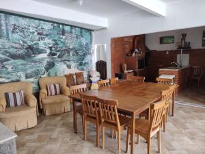 a dining room with a wooden table and chairs at Espaço 579 in Miguel Pereira