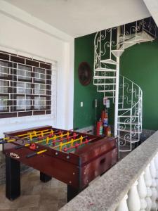 a pool table in a living room with a staircase at Espaço 579 in Miguel Pereira