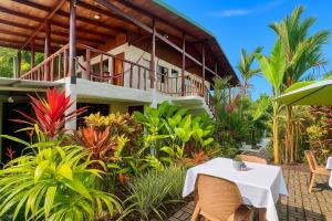 a house with a table in front of it at Mi Zaru Sea View Hotel Free Park Tour & Breakfast in Manuel Antonio