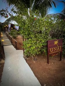 a sign for a hotel with a palm tree at Casa Flôr in Fernando de Noronha