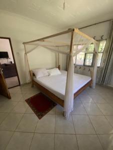 Double Room at Villa Soleil في شاطئ دياني: سرير مع مظلة في الغرفة +9 صور