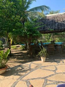 Double Room at Villa Soleil في شاطئ دياني: فناء به طاولة وكراسي وأشجار