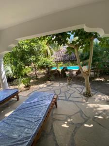 Double Room at Villa Soleil في شاطئ دياني: فناء مع مقعد وشجرة وحمام سباحة