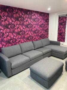 a living room with a couch and a flower wall at SuiteDreams - Ruby Suite Liège in Liège