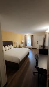 a hotel room with a large bed and a desk at ArabKnightsInn in Arab