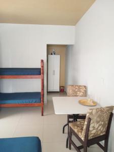 ピサーハスにあるcasaspraiagumsのテーブルと椅子、二段ベッドが備わる客室です。