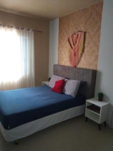 ピサーハスにあるcasaspraiagumsのベッドルーム1室(青いベッド1台、赤い枕付)