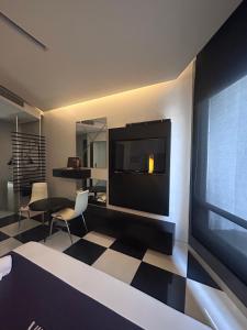 a hotel room with a television and a checkered floor at Auto Hotel Via Uno in Boca del Río