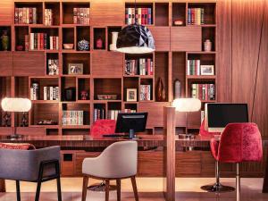 a library with a desk with chairs and books at Mercure Kuala Lumpur Shaw Parade in Kuala Lumpur