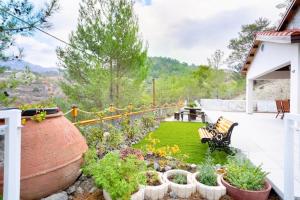 um jardim com um banco e algumas plantas em um quintal em Gazingstars Cottages Agridia 