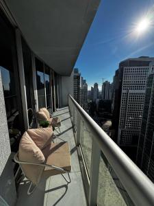 una persona sentada en una silla en el balcón de un edificio en ICON Brickell High Floor Condo - Balcony Skyline View - Amazing Spa, en Miami