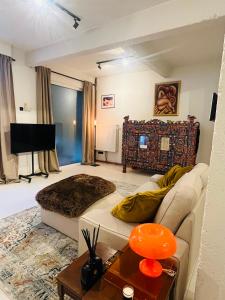 un soggiorno con un divano e una televisione di Casa Mia Terra Loft ad Anversa