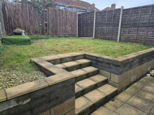 a garden with a brick retaining wall and a yard at Lantern House in Bristol