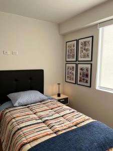 Moderno dpto de estreno en zona centrica في أريكيبا: غرفة نوم بسرير ولحاف ونافذة