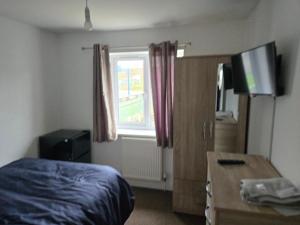 a bedroom with a bed and a desk and a window at Lantern House in Bristol